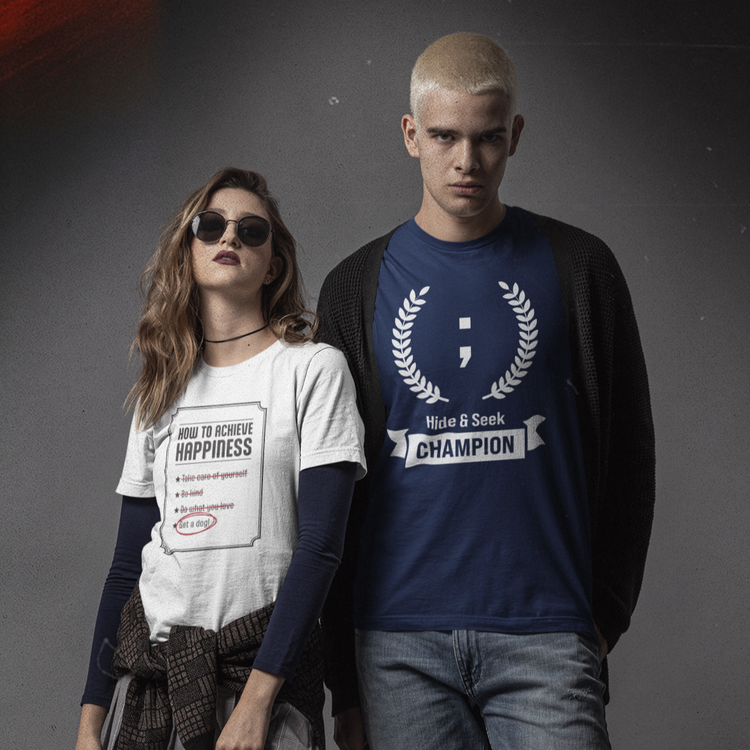 A young couple wearing geeky t-shirts. The woman wears a white dog t-shirt and the man wears a navy programming t-shirt.